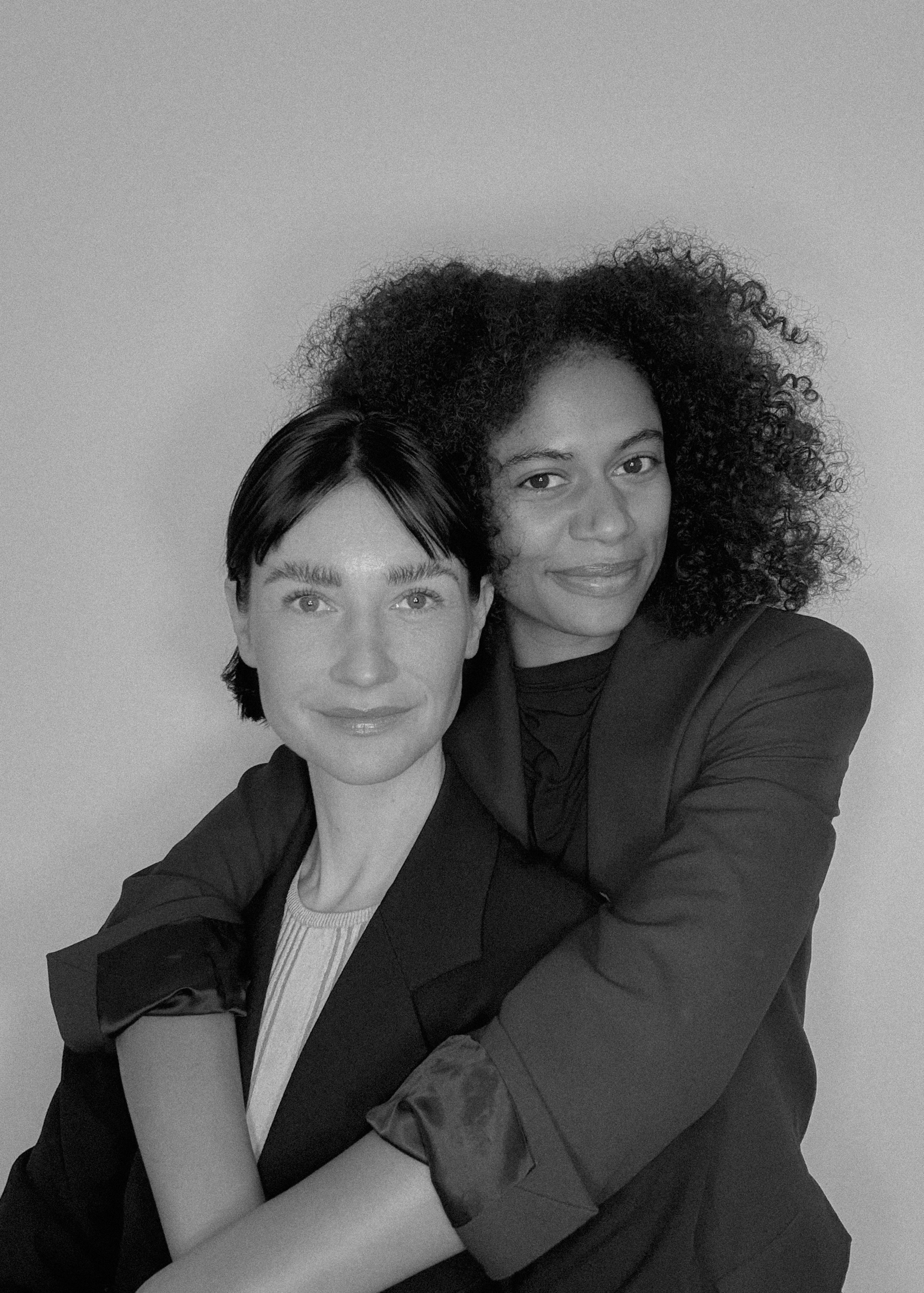 Amélie Baasner and Naïma Abt, founders of Let's Talk, Team!, embracing and smiling at the camera